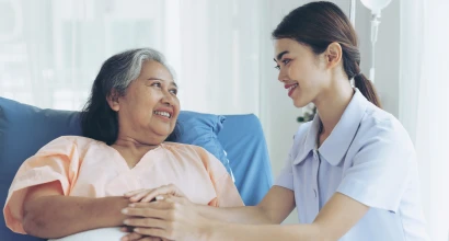 A woman sitting on a couch talking to a nurse