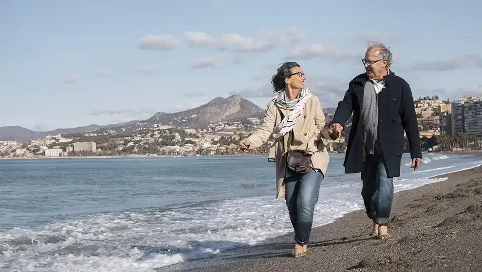 A man and a woman walking along a beach