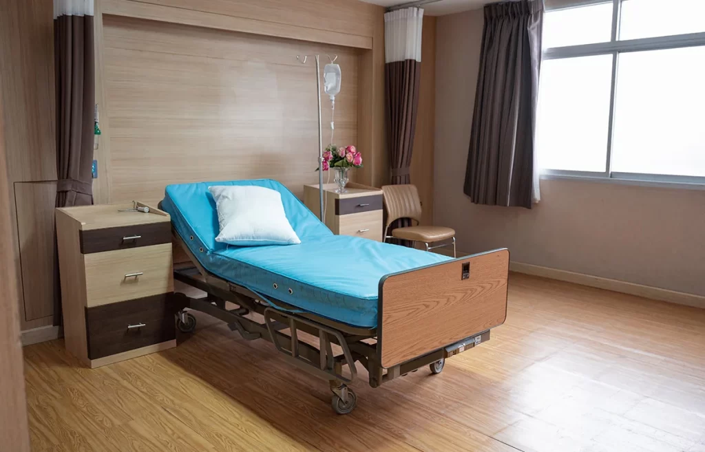 A hospital bed sitting in a room next to a window